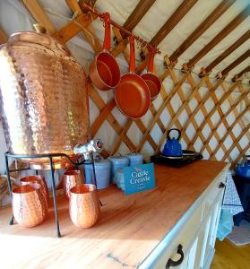 a counter with pots and pans hanging from a yurt at The Kites Rest at Castle Creavie Farm in Kirkcudbright