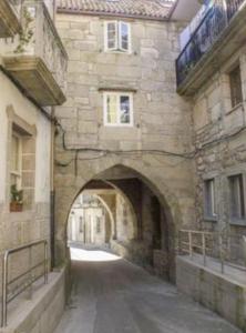 an archway in a stone building with a building at Vivienda 2 sin ascensor in Laxe