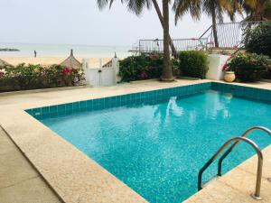 a swimming pool with a beach in the background at West AFRICAN BEACH in Saly Portudal