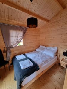 um quarto com uma cama num chalé de madeira em Zacisze Śniardwy em Nowe Guty