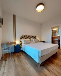 een slaapkamer met een groot wit bed en een tafel bij Nostos - Casale e Permacultura in SantʼAgata sui Due Golfi