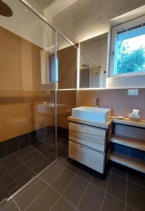 a bathroom with a sink and a glass shower at Nostos - Casale e Permacultura in SantʼAgata sui Due Golfi