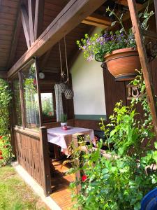 eine Veranda eines Hauses mit einem Tisch und Blumen in der Unterkunft Ferienhaus Mautzfried in Reisach