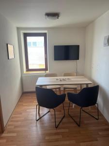 a room with a table and two chairs and a tv at Apartmán Hotel Vomočil Bystré in Bystré