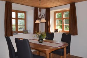 a dining room with a wooden table and chairs at Holstein-Höfle, ArgenInsel in Argenbühl