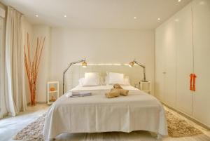 Un dormitorio con una cama grande con un osito de peluche. en PLAYAS DEL DUQUE, PUERTO BANUS, GOLF .PLAYA Y COMPRAS, en Marbella