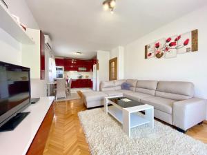 a living room with a white couch and a tv at Guest House Ivano in Mostar
