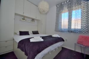 - une chambre avec un lit et des serviettes dans l'établissement Apartman Staro Selo, à Primošten