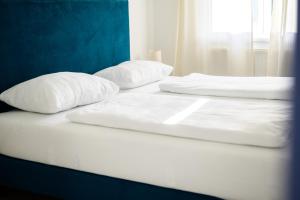 2 Betten mit weißer Bettwäsche und Kissen darauf in der Unterkunft Seeappartements Christiane Haus 95 in Leinsdorf