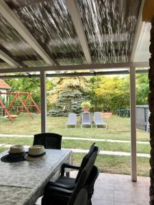 a screened in porch with a table and chairs at Viharsarki Apartman in Gyula