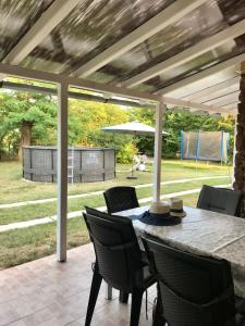 eine Terrasse mit einem Tisch mit Stühlen und einem Sonnenschirm in der Unterkunft Viharsarki Apartman in Gyula