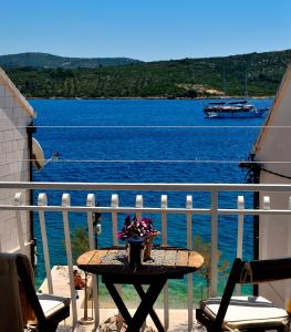 - une table sur un balcon avec vue sur l'eau dans l'établissement Apartman Staro Selo, à Primošten