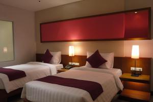 una habitación de hotel con 2 camas y una pantalla grande en @Judy, en Patong Beach