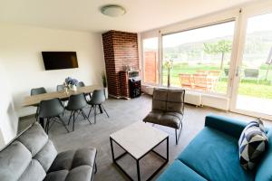 ein Wohnzimmer mit einer Couch und einem Tisch und Stühlen in der Unterkunft Seeappartements Christiane Haus 95 in Leinsdorf