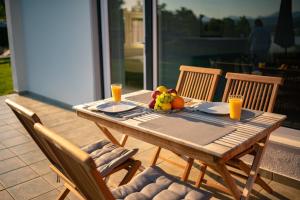einen Holztisch mit einer Schale Obst und Orangensaft in der Unterkunft Seeappartements Christiane Haus 95 in Leinsdorf + 17 Fotos