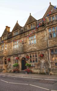 un vecchio edificio in pietra con le bandiere di Stylish one bedroom Cotswold Coach House Tetbury a Tetbury
