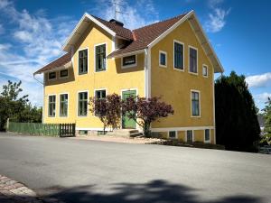 una casa amarilla al lado de una calle en Sjögatan 21, en Gränna