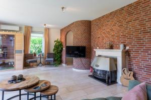 a living room with a brick wall and a fireplace at Inner Stillness Wellness Retreat in Albergen