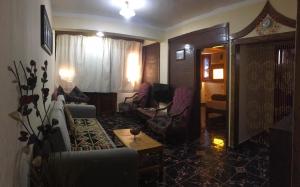 uma sala de estar com cadeiras, um sofá e uma mesa em Dahab Home bed&breakfast em Dahab