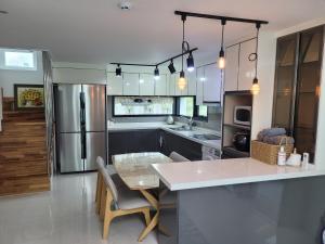 a kitchen with a counter and a table in it at Saeville Stay in Jeju