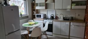 a small kitchen with a table and a microwave at Domek Adam - Kozy in Kościerzyna