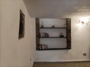 una habitación con un estante con DVD en la pared en lotus flower en Sant'Olcese