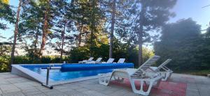 a group of chairs sitting next to a swimming pool at Vila Sinfonia, a house with a pool in Velika Remeta