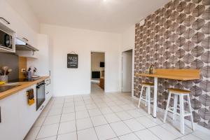 a kitchen with a counter and stools at Le Logis à Mimine in Montrevault