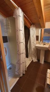 a bathroom with a shower curtain and a sink at Casa Rural T-Rex in Bretún