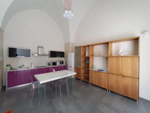 a kitchen with a white table and purple cabinets at Appartamento Negroamaro in Galatina