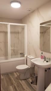 a white bathroom with a toilet and a sink at Apartamento Buenavista in Villamiel