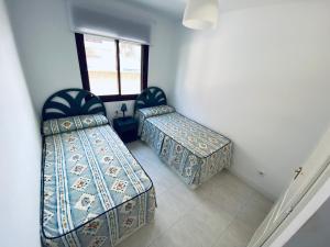 カルプにあるPrimera línea de playa, Topacio 1のベッド2台と窓が備わる客室です。