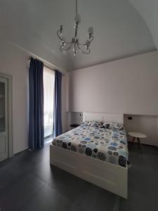 a bedroom with a bed and a chandelier at Appartamento Negroamaro in Galatina