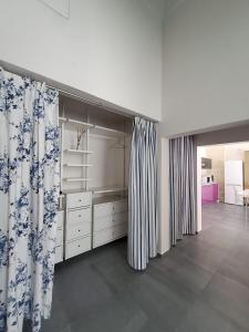 a large room with white cabinets and curtains at Appartamento Negroamaro in Galatina
