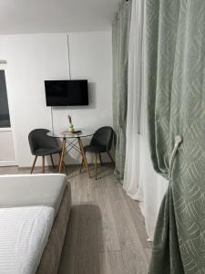 a bedroom with a bed and a table and a television at La Mosie in Corbu
