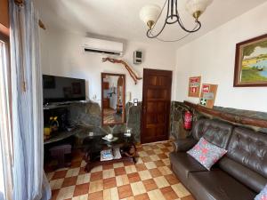 ein Wohnzimmer mit einem Ledersofa und einem Spiegel in der Unterkunft Fonte da telha Beach House in Costa da Caparica