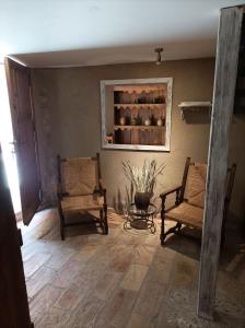 ein Wohnzimmer mit 2 Stühlen und einem Regal in der Unterkunft Casa Zapatero en Somontano in Salas Bajas