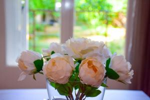 eine Vase voller weißer Blumen auf einem Tisch in der Unterkunft Filoxenia Apartment Athens in Athen