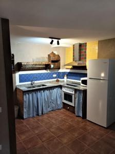 eine Küche mit einem weißen Kühlschrank und einer Spüle in der Unterkunft Casa Zapatero en Somontano in Salas Bajas