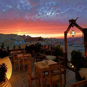 瓦迪穆薩的住宿－Petra Desert Dream Hotel，一间带桌椅的餐厅,享有日落美景