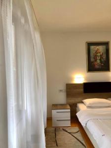 a bedroom with two beds and a white curtain at Konak Nestor Bungalows in Skopje