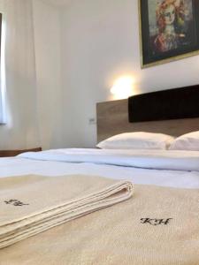 two beds with white sheets and a towel on them at Konak Nestor Bungalows in Skopje