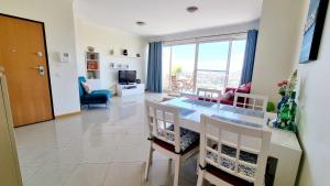 a kitchen and living room with a table and chairs at Sea View Penthouse in Albufeira in Albufeira