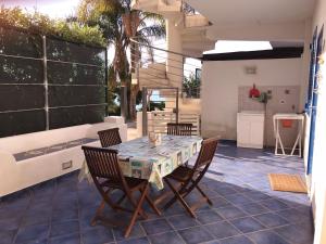 patio con mesa y sillas y cocina en Magico Appartamenti Scafa - Marina Capo d'Orlando, en Capo dʼOrlando