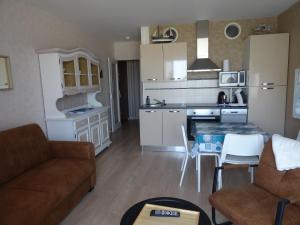 Una cocina y una sala de estar con un sofá y una mesa. en Studio alcôve, vue mer, 4 personnes, Saint Jean de Monts, en Saint-Jean-de-Monts