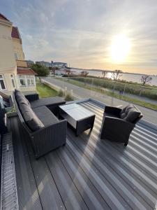 una terraza con 2 sofás y una mesa en el techo en Wohnungen mit direktem Meerblick, en Laboe