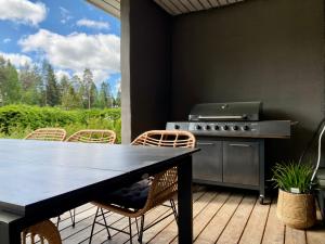 un patio con mesa y parrilla en Idyllic Villa Unikko With Jacuzzi And Sauna en Pori