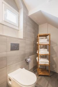 uma casa de banho com WC e uma prateleira com toalhas em ONAR PORTO RAFTI em Porto Rafti