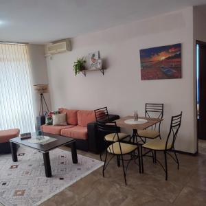 a living room with a couch and a table and chairs at Апартамент FLAME in Sunny Beach