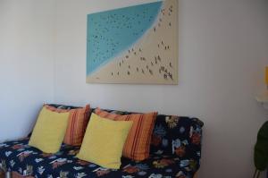 a couch with pillows and a painting on the wall at Apartments Burcul Pag in Pag